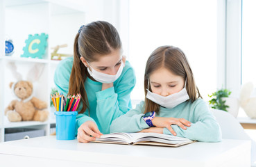 Fototapeta premium Home schooling of cute sisters during pandemic