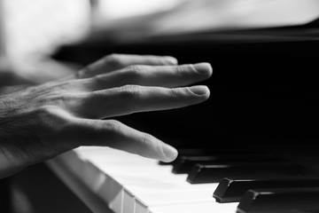 hands of a man playing the piano during the day, stylish photo