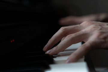 hands of a man playing the piano during the day, stylish photo