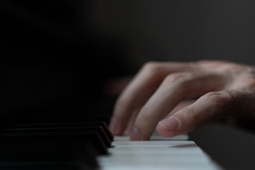 Fototapeta premium hands of a man playing the piano during the day, stylish photo
