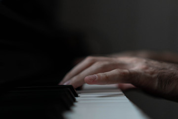 hands of a man playing the piano during the day, stylish photo