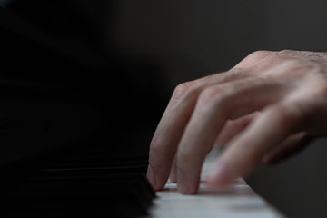 hands of a man playing the piano during the day, stylish photo