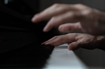Obraz premium hands of a man playing the piano during the day, stylish photo