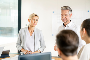 Senior businessman and woman leading workshop in office