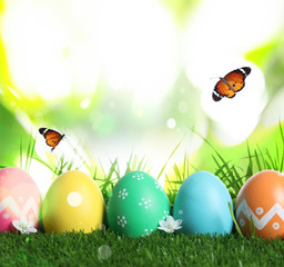 Colorful Easter eggs and butterflies on blurred green background