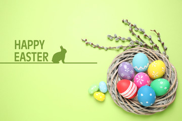 Flat lay composition with bright eggs and text Happy Easter on green background