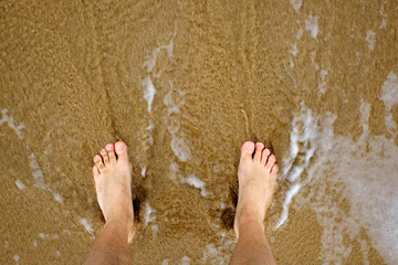 Bare feet on the beach shore