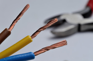 stripped three-wire electric cable on a light background.