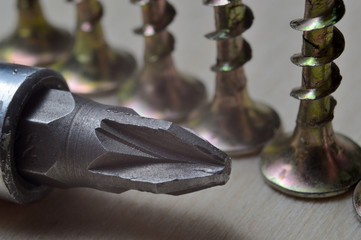 yellow screws and a screwdriver. close-up.