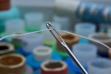 needle with thread on a background of coils. close-up.