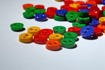 small multi-colored buttons on a white background. close-up.