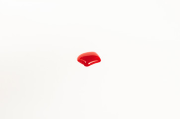 Blood droplet on white paper background.