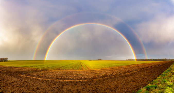 UK, Scotland, Panorama of double rainbow over agricultural field