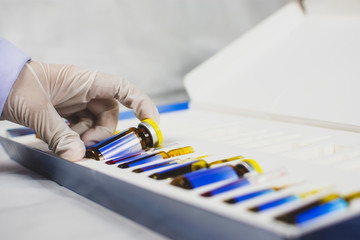 The doctor's hand is picking up the medicine vial bottle from box set,Coronavirus treatment...