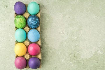 Fototapeta na wymiar colorfully painted easter eggs on green background with copy space