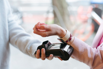 Hand of woman, paying cashless at POS terminal with her smartwatch
