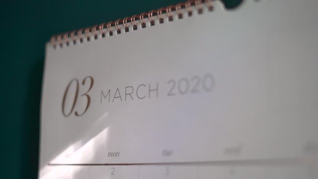 Macro shot of a calendar on the March year twenty-twenty page fixed to the wall with a push pin