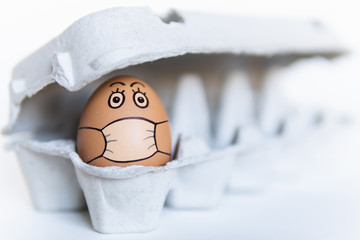 Chicken egg in a tray with doodle face wearing medical mask. Conceptual image of stay at home...