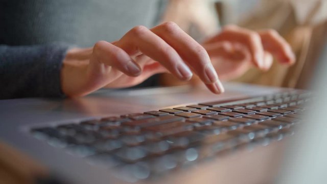 Close-up of female hands typing laptop keyboard. young woman using laptop