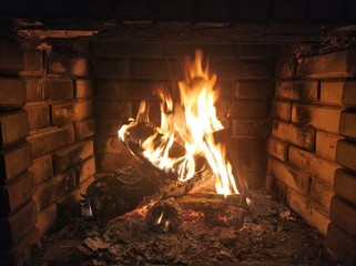 Fire in a stone fireplace with wood