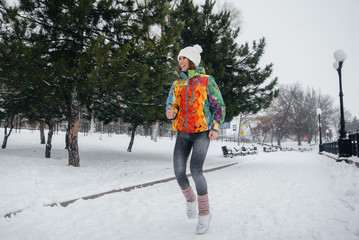 A beautiful young girl is Jogging on a frosty and snowy day. Sports, healthy lifestyle