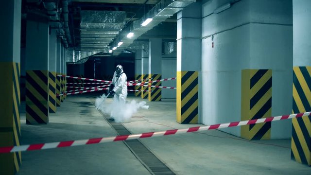 Chemical fumigation of an empty storage space. Worker disinfecting indoors using chemicals, coronavirus prevention concept.