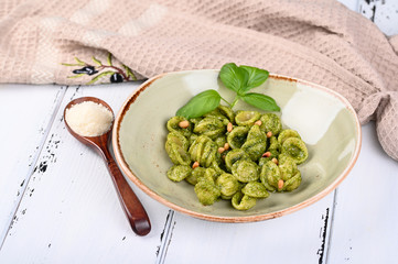 Italian pasta named Orecchiette with pesto of Genoa, sauce and parmesan cheese