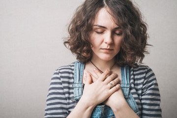 Woman hands on his chest. Gray background.