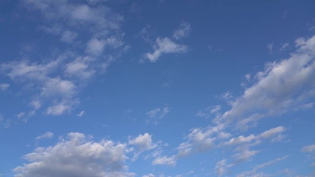 Video time lapse of beautiful clear sunny blue sky with soft fluffy white clouds moving alone. Natural background.