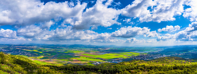 panorama of valley, green fields, pastures, clouds 