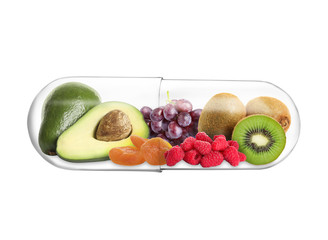 Transparent capsule with different fruits and berries rich in vitamins on white background