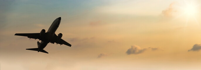 Airplane taking off at sunset. Silhouette of a big passenger or cargo aircraft, airline. Transportation
