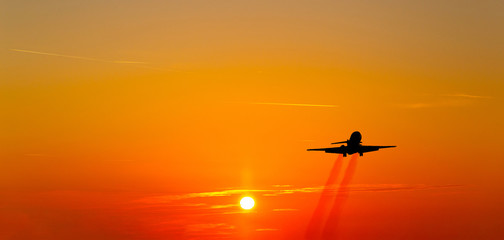 Airplane taking off at sunset. Silhouette of a big passenger or cargo aircraft, airline. Transportation.