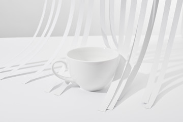 close up view of paper stripes and cup on white background