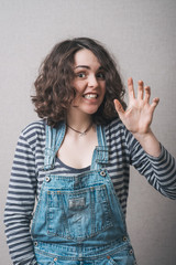 Woman playfully scared hand grimace. Gray background