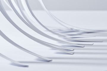 close up view of curved paper stripes on white surface