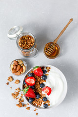 Homemade oatmeal granola bowl with greek yogurt, berries, honey and nut