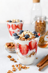 Granola parfait with greek yogurt, oat cereal, fresh berries, honey in glass jar