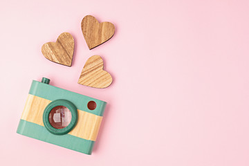 Flat lay with toy wooden camera and hearts. Social media, posts, likes, followers, online photography classes concept. Top view