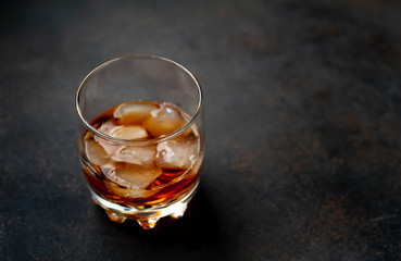 glass of whiskey with ice on a stone background with copy space for your text