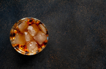 glass of whiskey with ice on a stone background with copy space for your text