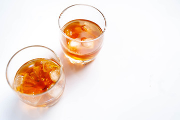Two glasses with whiskey on a white background