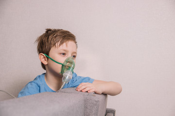 The boy is treated with a nebulizer to get rid of cough, cure pneumonia, coronavirus, bronchitis