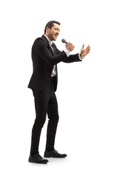 Man in a black suit singing on a microphone