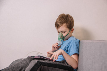 The boy is treated with a nebulizer to get rid of cough, cure pneumonia, coronavirus, bronchitis