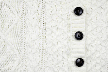 Closeup of white knitted textile detail of cardigan for background