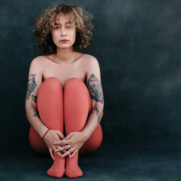 sad topless woman in orange tights