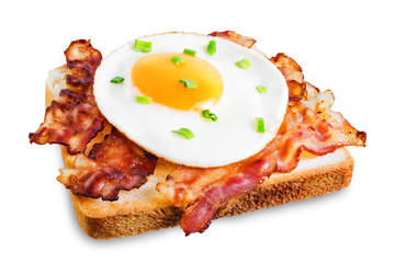Fried egg fried bacon sandwich on a white isolated background