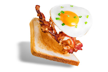 Fried egg fried bacon sandwich on a white isolated background