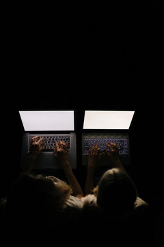 Mother and Daughter working at night with laptops photographed from above.